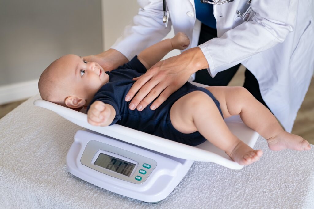 Doctor weighing baby